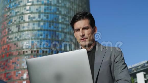 商人在街上用笔记本电脑读好消息手提电脑的人视频的预览图