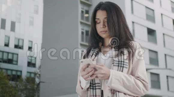 女商人在街上用智能手机发短信使用手机的专注女孩视频的预览图