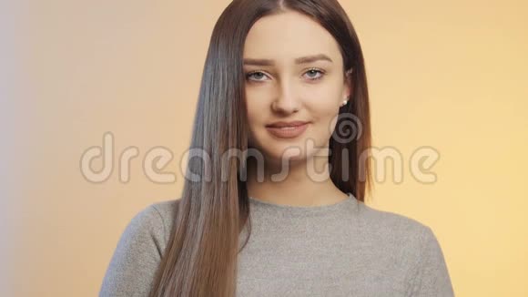 美丽的女孩在彩色的工作室背景上微笑一个年轻的女人的脸上化妆概念女性美容和皮肤护理视频的预览图