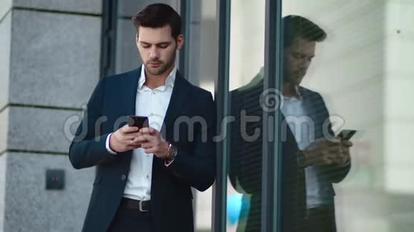贴身男站在外面拿着电话在街上使用智能手机的商人视频的预览图
