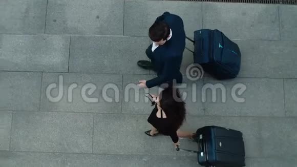 顶景夫妇步行与手提箱商务情侣在一起聊天视频的预览图
