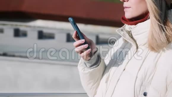 年轻女孩拿着电话在外面视频的预览图