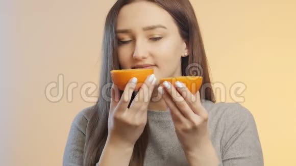 可爱的女孩手里拿着一半的橘子水果女孩做可爱的脸滑稽的情绪积极的情绪视频的预览图