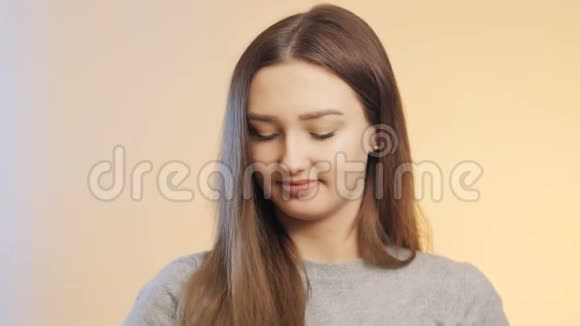 美丽积极的女孩摆姿势手里拿着一半的橙色水果在彩色的工作室背景下女性广告节食骗局视频的预览图