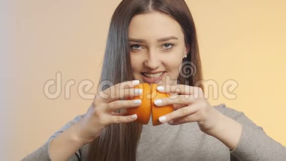 可爱的女孩互相摩擦一半的橘子挤压果汁的过程健康饮食的概念和生活方式视频的预览图