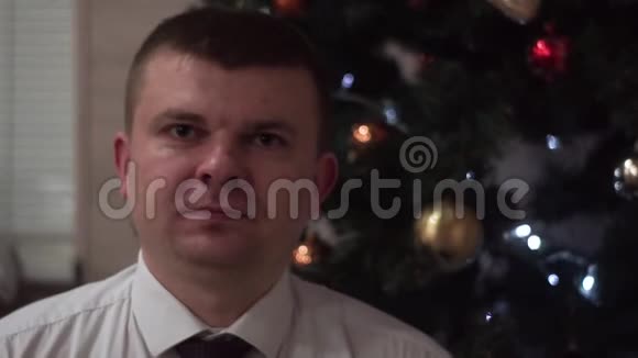 穿着白衬衫领带的人用双手显示了他的心圣诞树背景视频的预览图