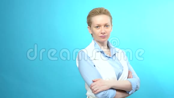 蓝色背景上没有化妆的金发女人的肖像复制空间视频的预览图