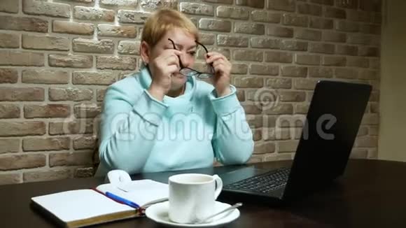 工作的老年妇女在阁楼里用笔记本电脑视频的预览图