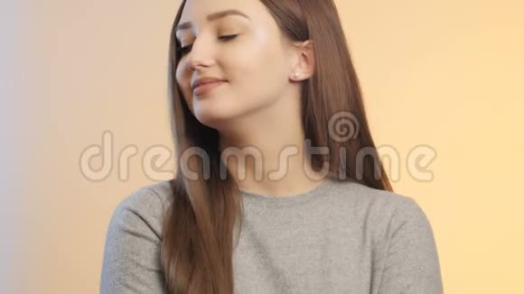 美丽的女孩在彩色的工作室背景上微笑一个年轻的女人的脸上化妆概念女性美容和皮肤护理视频的预览图