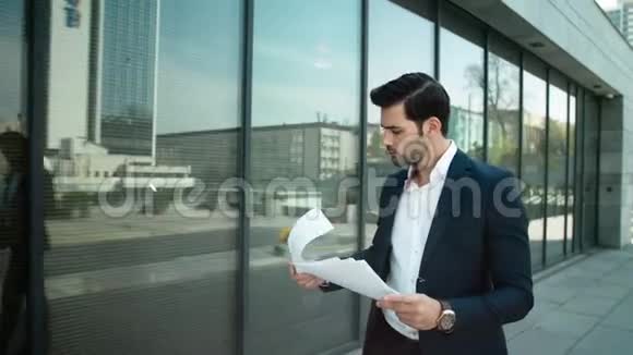 贴身男在街上拿着文件走商人在室外阅读文件视频的预览图