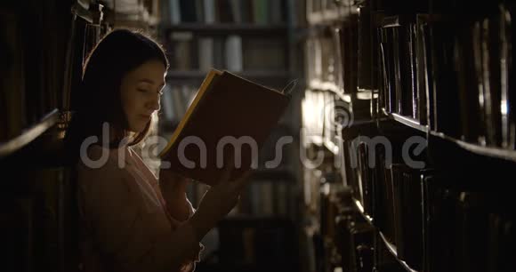 女人在黑暗图书馆看书视频的预览图