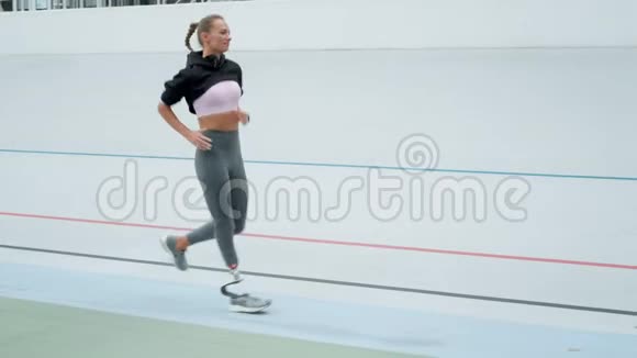 残疾运动员女子在运动跑道上跑步女运动员在跑道上慢跑视频的预览图
