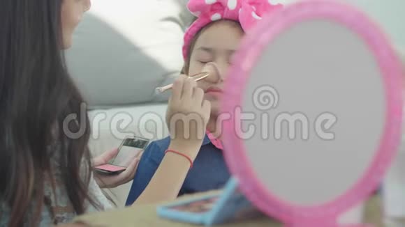 孩子们对着镜子两个姐妹在化妆视频的预览图
