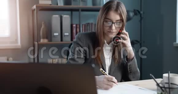 女经理在电话交谈时做笔记视频的预览图