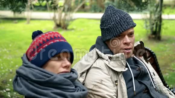 一对无家可归的夫妇一对男女在城市公园的长椅上视频的预览图