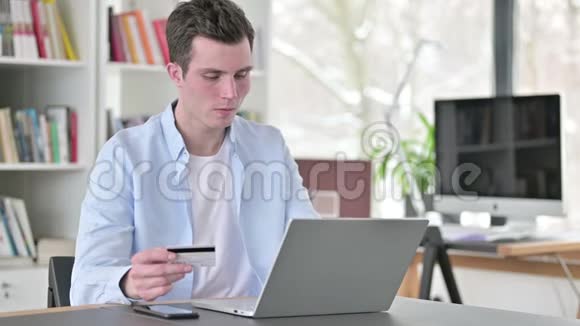 年轻人在笔记本电脑上成功的网上购物视频的预览图