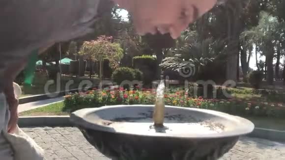 口渴的人在公园的室外饮用喷泉夏季炎热炎热的日子视频的预览图