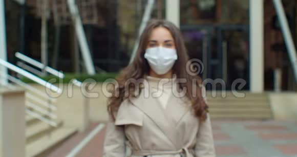 一位年轻的旅游妇女戴着保护面具在街头人群中的肖像健康与安全的概念视频的预览图