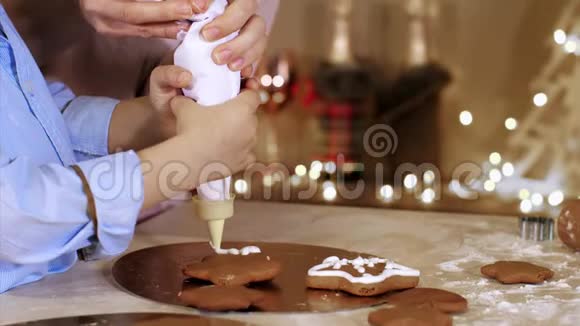 妈妈和儿子一起装饰一个圣诞姜饼饼干和糕点包视频的预览图