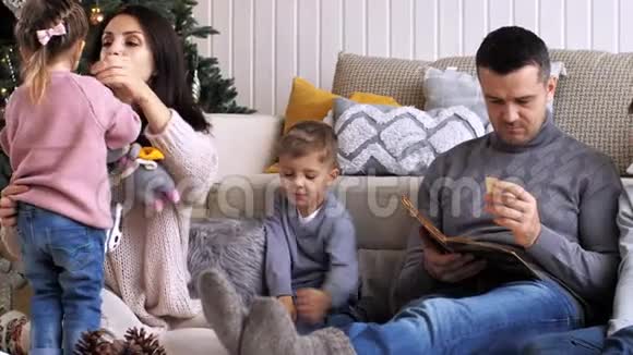 有三个孩子的家庭在圣诞前夜一起在家里度过视频的预览图