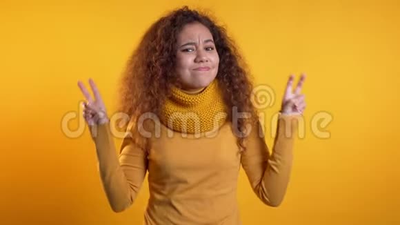 一个漂亮的卷发女孩用双手和两个手指做手势视频的预览图