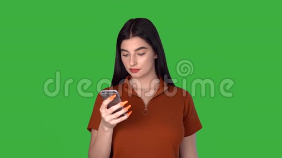 年轻的女人拿着电话聊天女孩在绿色屏幕上发短信视频的预览图