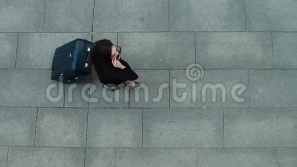 俯视图的女人把太阳镜放在户外带着手提箱走路的女人视频的预览图