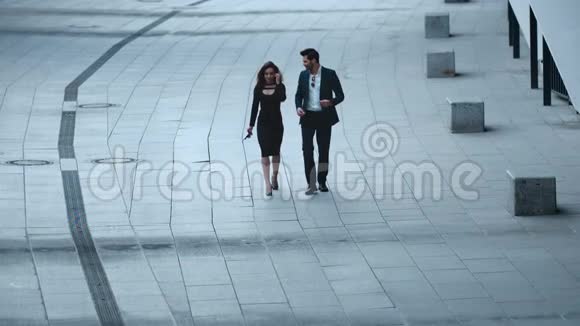 商务夫妇穿着时髦的衣服说话商务夫妇在人行道上散步视频的预览图