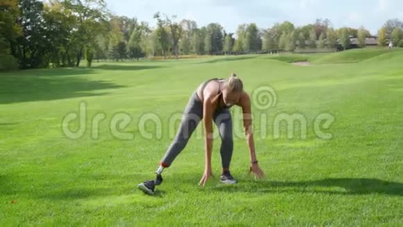 残疾适合妇女在公园伸展腿准备户外运动的女士视频的预览图