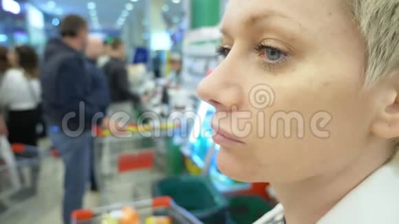 超市里一个疲惫的女人的肖像特写视频的预览图