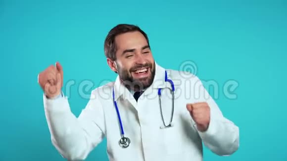 年轻医生穿着职业白大褂在蓝工作室背景上被隔离视频的预览图