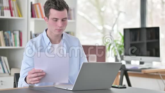 年轻人阅读文件手提电脑视频的预览图