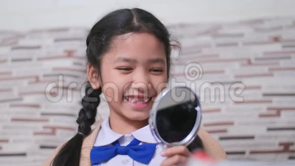 小亚洲女孩看着镜子检查她的嘴寻找一颗破碎的牙齿带着快乐的情绪为牙齿和医疗服务c视频的预览图