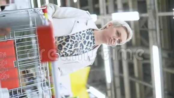 垂直射击超市里时尚女性与购物车的肖像视频的预览图