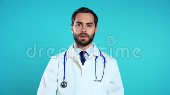 戴着职业白大褂的医生用手指在蓝色嘴唇上的画像视频的预览图