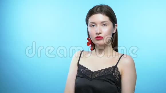 一个漂亮女孩的肖像蓝色背景那个女孩戴耳环视频的预览图