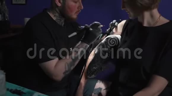 男子为妇女做黑蛇纹身视频的预览图