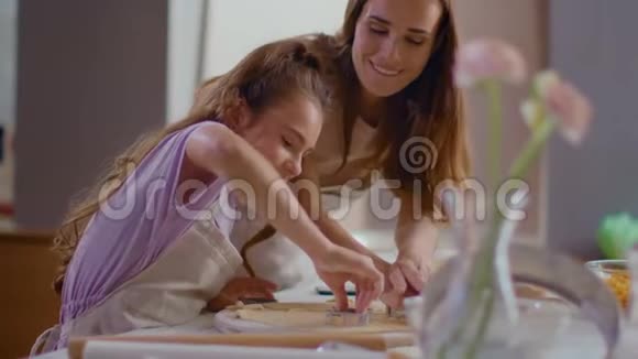 幸福的母女用切饼机准备饼干的画像视频的预览图