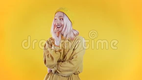 年轻漂亮的白发女孩站在黄色的工作室背景上视频的预览图
