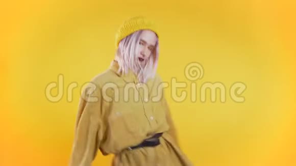 美丽的女人粉红色的头发和穿心的舞蹈模因在黄色的舞蹈视频的预览图