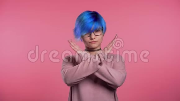 年轻的不寻常的女人蓝色的头发没有交叉的手标志否定的手势在粉红色的工作室背景上视频的预览图