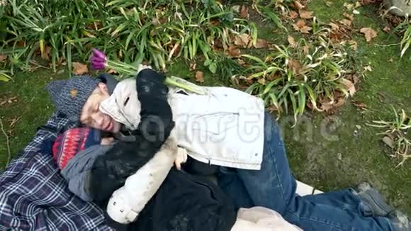无家可归的男人和女人躺在花园附近的公园的纸板上视频的预览图