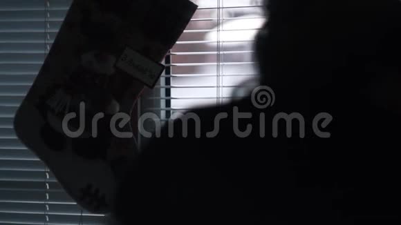 一个女孩的剪影来到一个金属塑料窗户有百叶窗视频的预览图