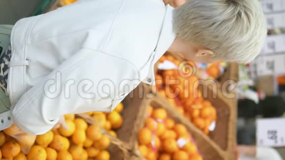垂直射击特写镜头女人在超市里挑橘子视频的预览图