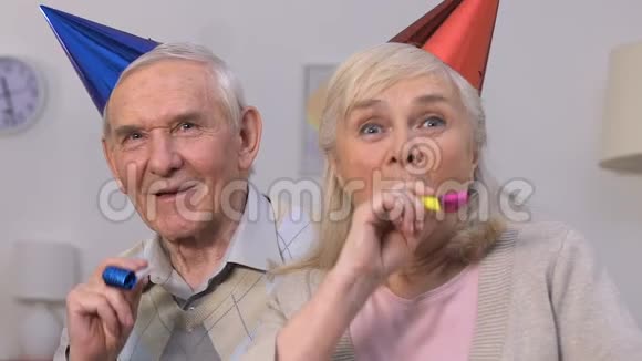 有趣的老夫妇戴着派对帽享受着庆祝活动一起玩得很开心视频的预览图