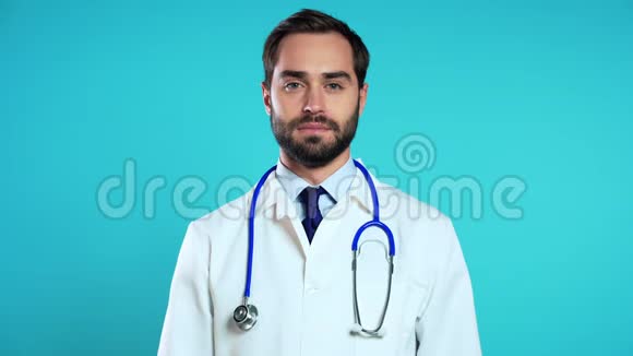 穿着职业医疗白大褂的英俊男子的肖像被隔离在蓝色上视频的预览图