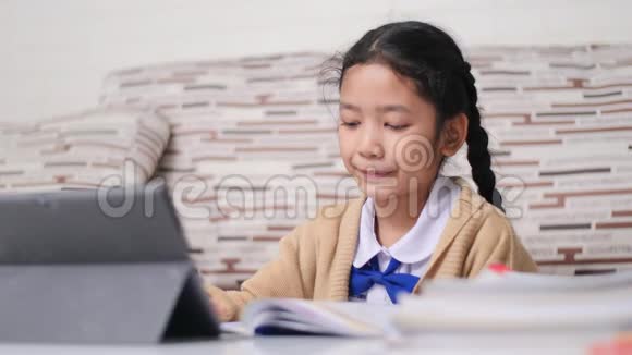小亚洲女孩快乐地做作业泰国女孩穿着学生幼儿园的制服在家学习和教育视频的预览图