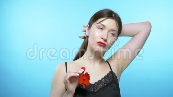 一个漂亮女孩的肖像蓝色背景女孩戴耳环视频的预览图