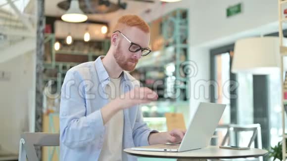 咖啡厅头痛的红发男子在手提电脑上工作视频的预览图