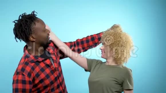 非洲男人和高加索女人有非洲发型蓝色背景视频的预览图